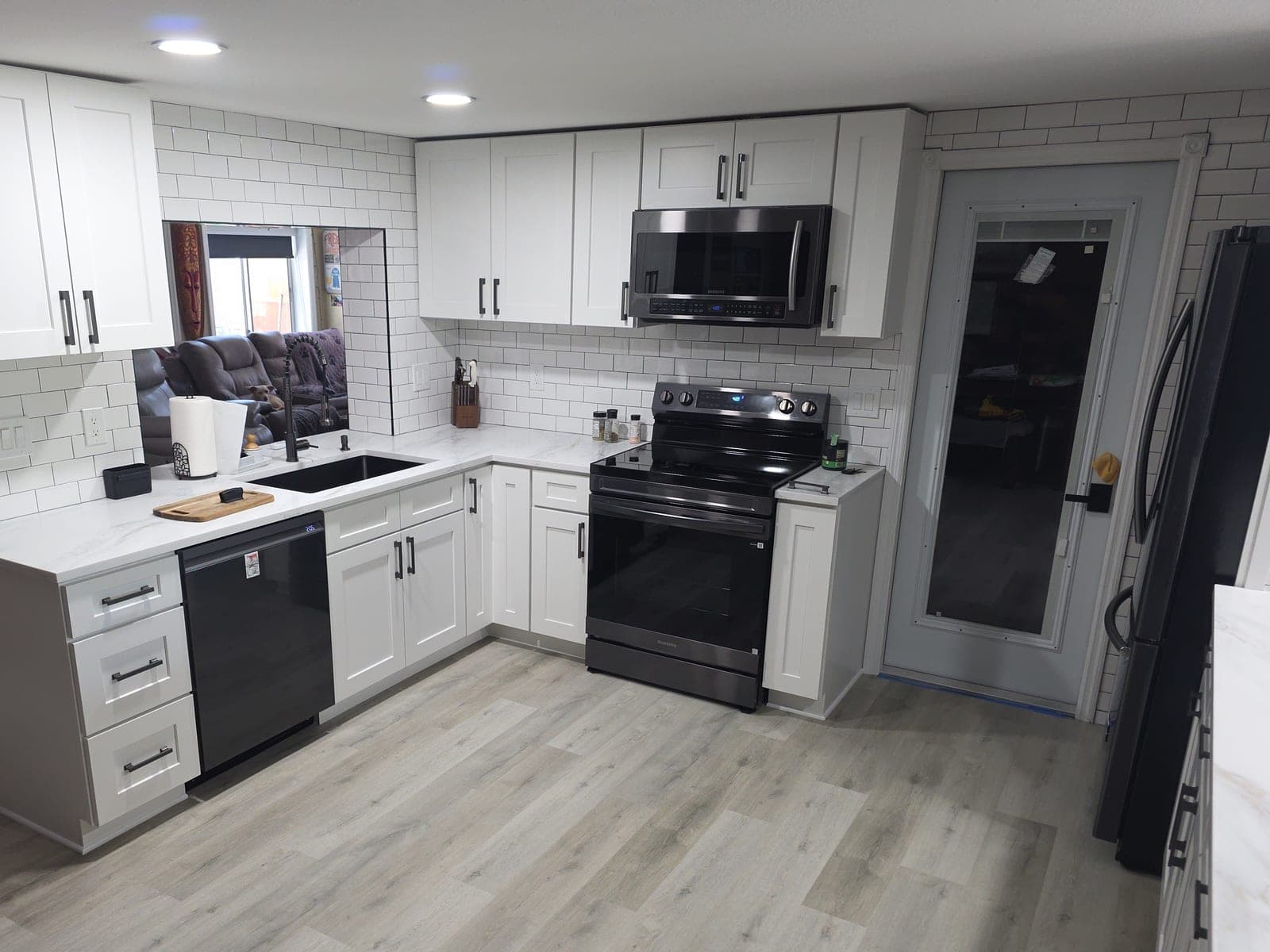 Kitchen with white shaker cabinets, subway tile backsplash, and quartz countertops