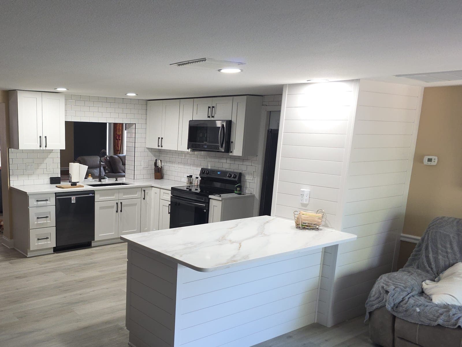 White shaker kitchen with shiplap peninsula and quartz countertop, renovated by Jason Sutliff Renovations